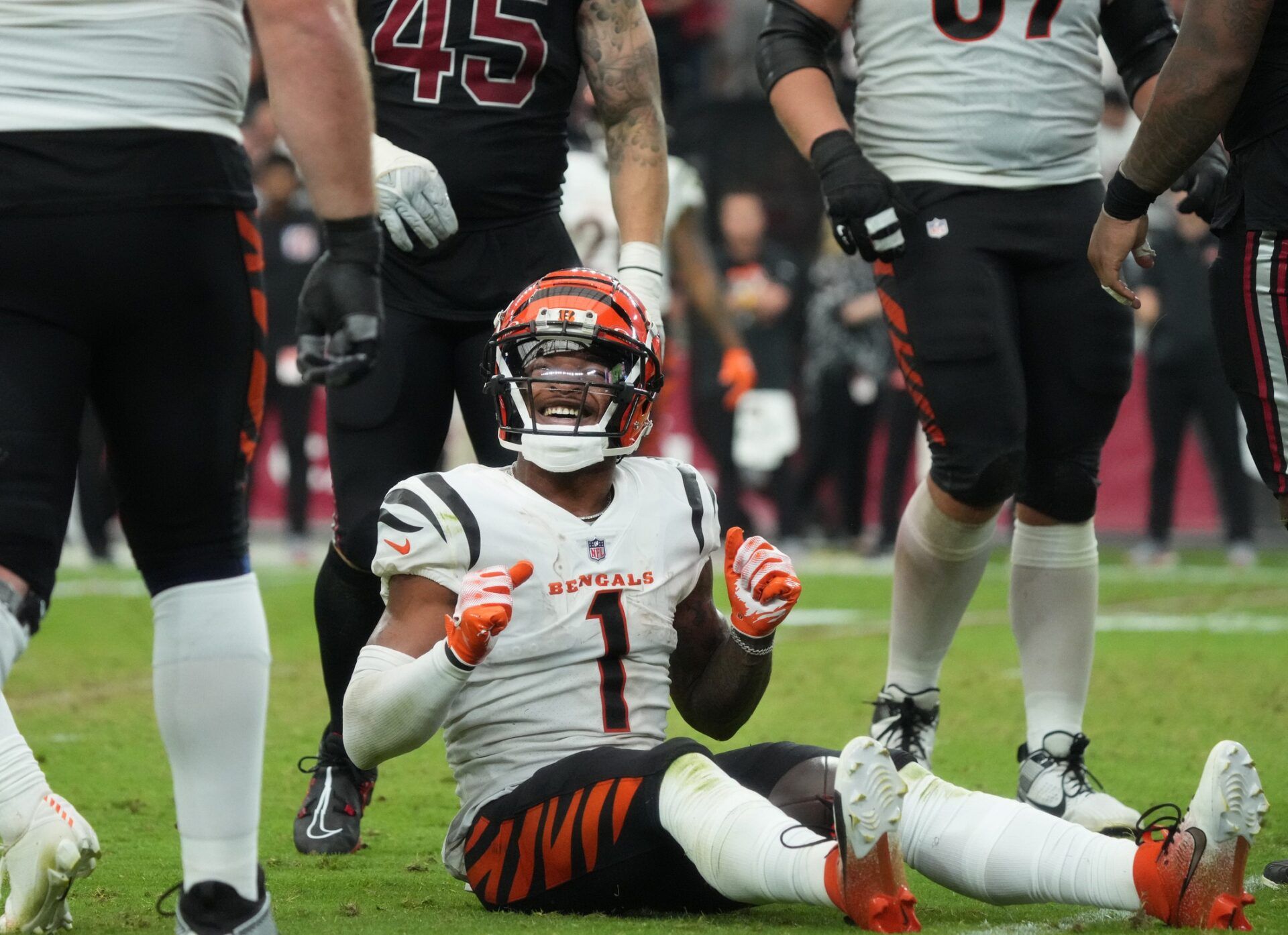 Ja'Marr Chase (1) smiles from the ground after a first down reception against the Arizona Cardinals at State Farm Stadium.