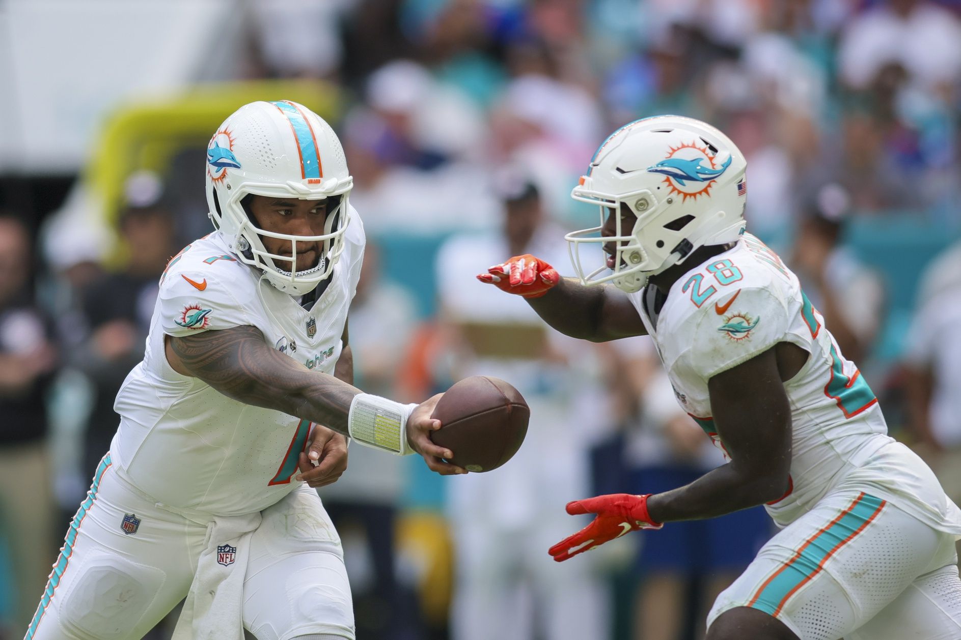 Tua Tagovailoa (1) hands out the football to running back De'Von Achane (28) against the New York Giants during the fourth quarter at Hard Rock Stadium.