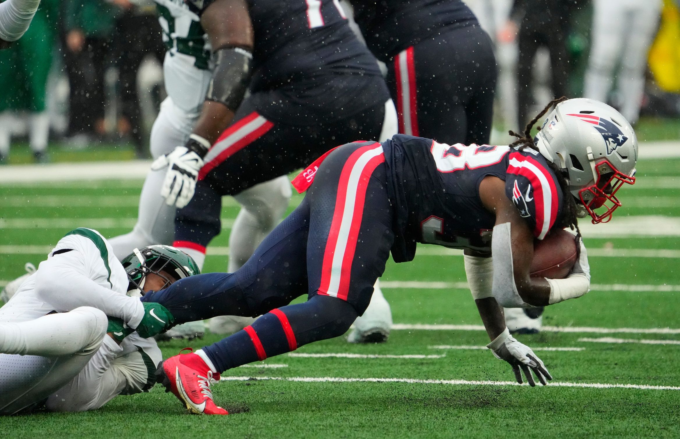 New York Jets safety Jordan Whitehead (3) hangs on to New England Patriots running back Rhamondre Stevenson (38) at MetLife Stadium.