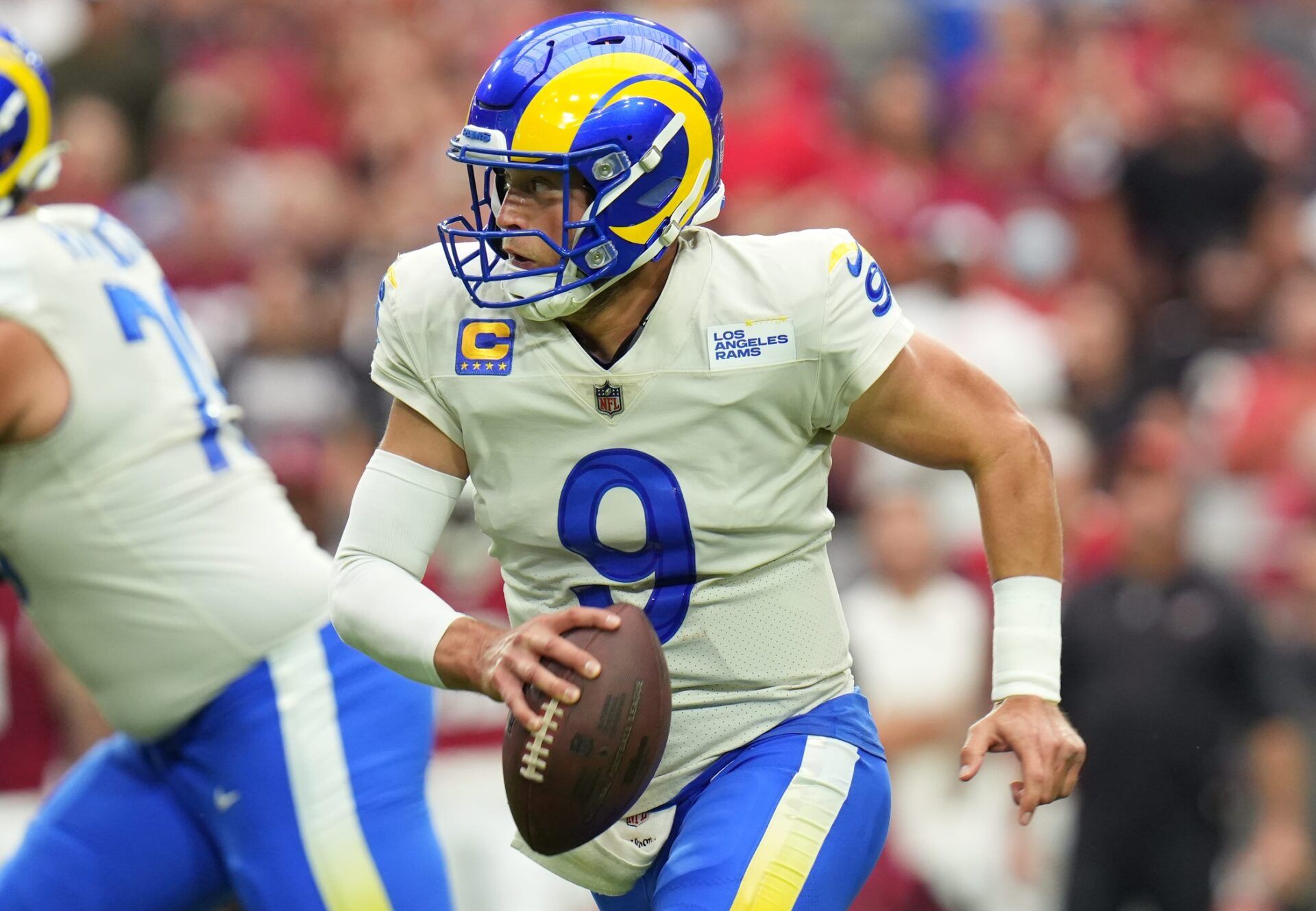 Los Angeles Rams QB Matthew Stafford (9) rolls out with the ball against the Arizona Cardinals.