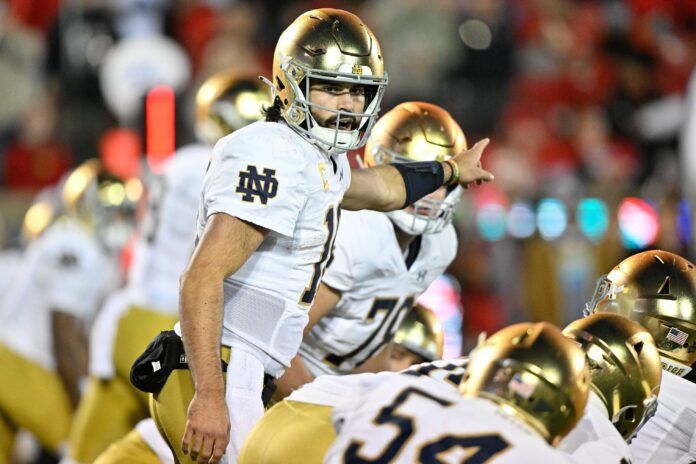 Sam Hartman (10) adjusts a play call during the first half against the Louisville Cardinals at L&N Federal Credit Union Stadium.