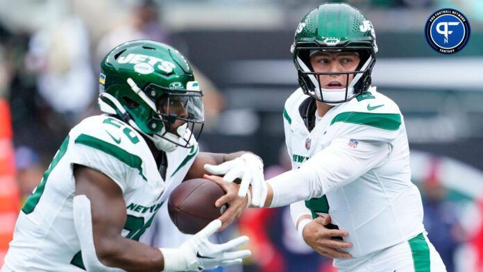 New York Jets quarterback Zach Wilson (2) hands the ball to running back Breece Hall (20) in the first half against the New England Patriots.