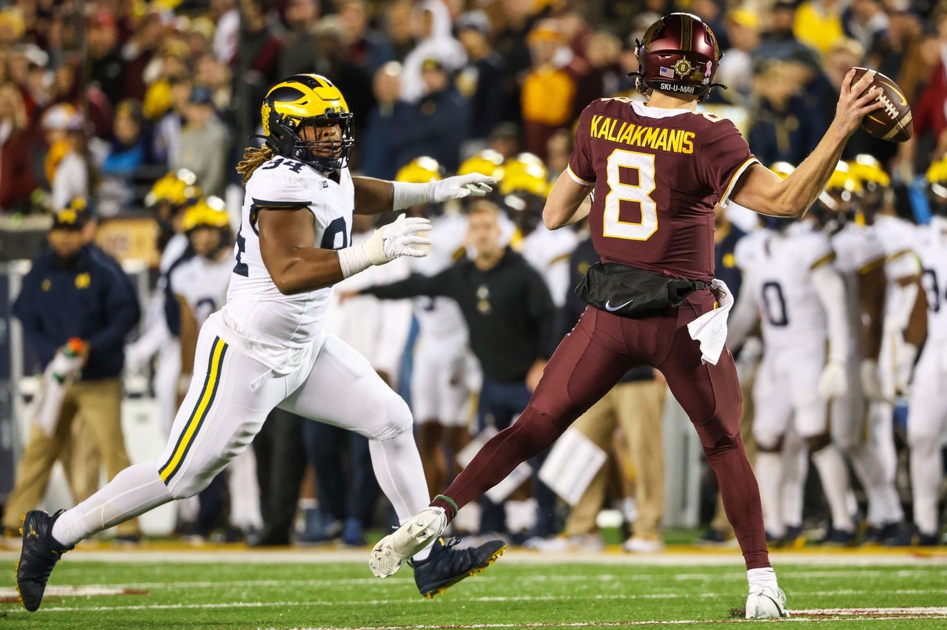Minnesota Golden Gophers quarterback Athan Kaliakmanis (8) throws while Michigan Wolverines defensive lineman Kris Jenkins (94) defends during the third quarter at Huntington Bank Stadium.
