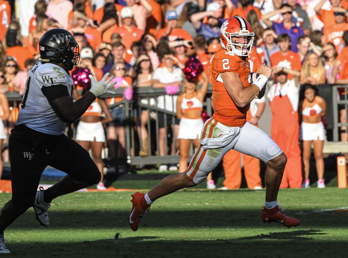 Clemson Tigers quarterback Cade Klubnik (2) runs by Wake Forest Demon Deacons defensive lineman Jasheen Davis (30).