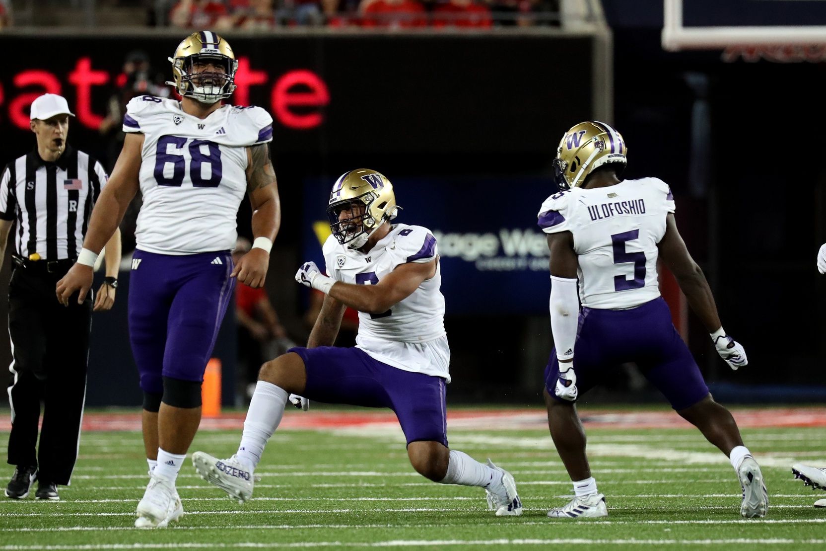 Bralen Trice (8), defensive lineman Ulumoo Ale (68), and linebacker Edefuan Ulofoshio (5) celebrate a tackle for a loss in the second half at Arizona Stadium.