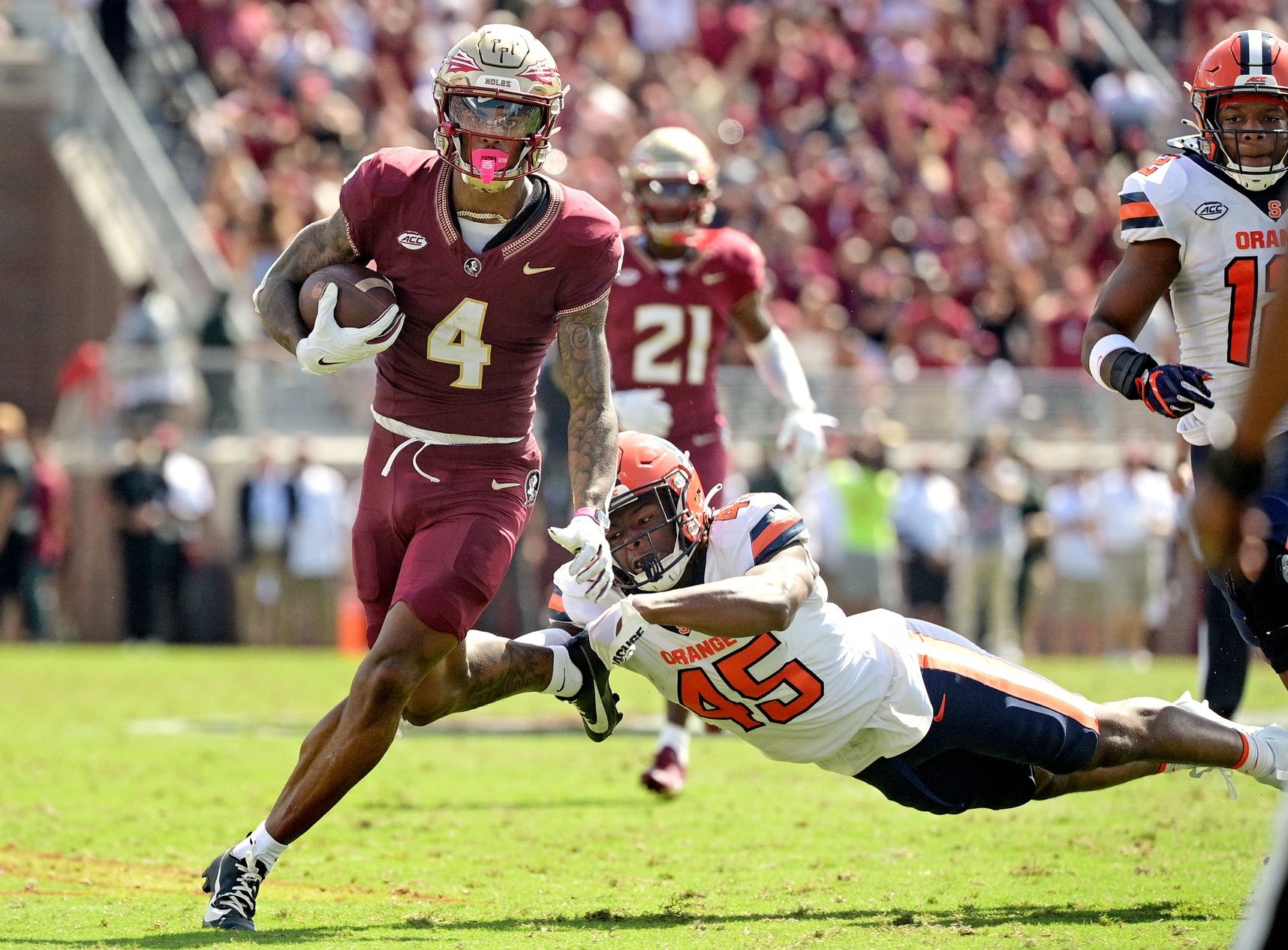 Keon Coleman (4) avoids a tackle by Syracuse Orange linebacker Kadin Bailey (45) during the first quarter at Doak S. Campbell Stadium.