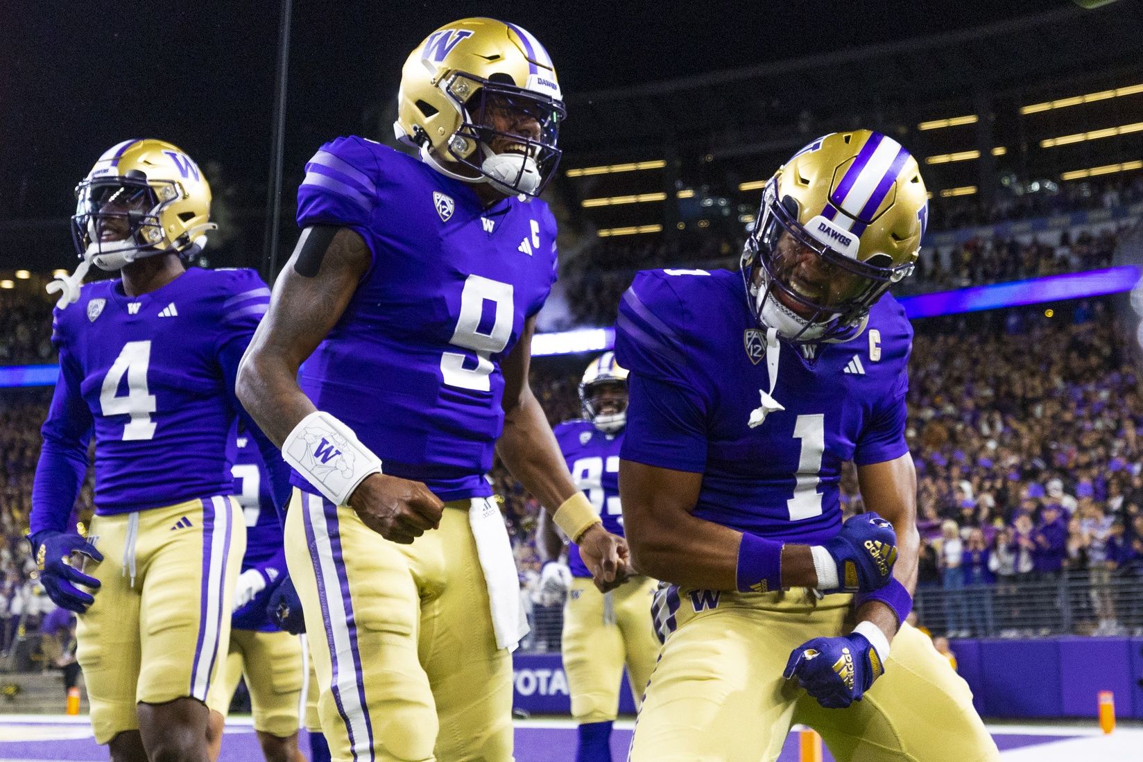 Rome Odunze (1) celebrates with quarterback Michael Penix Jr. (9) after returning a punt for a touchdown during the first quarter at Alaska Airlines Field at Husky Stadium.