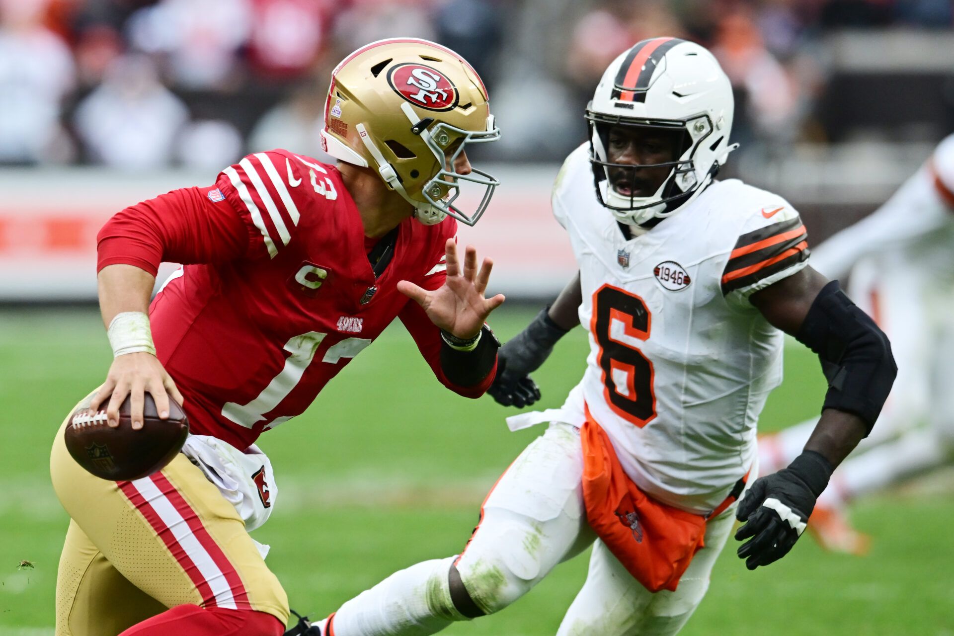 San Francisco 49ers quarterback Brock Purdy (13) scrambles from Cleveland Browns linebacker Jeremiah Owusu-Koramoah (6) during the second half at Cleveland Browns Stadium.