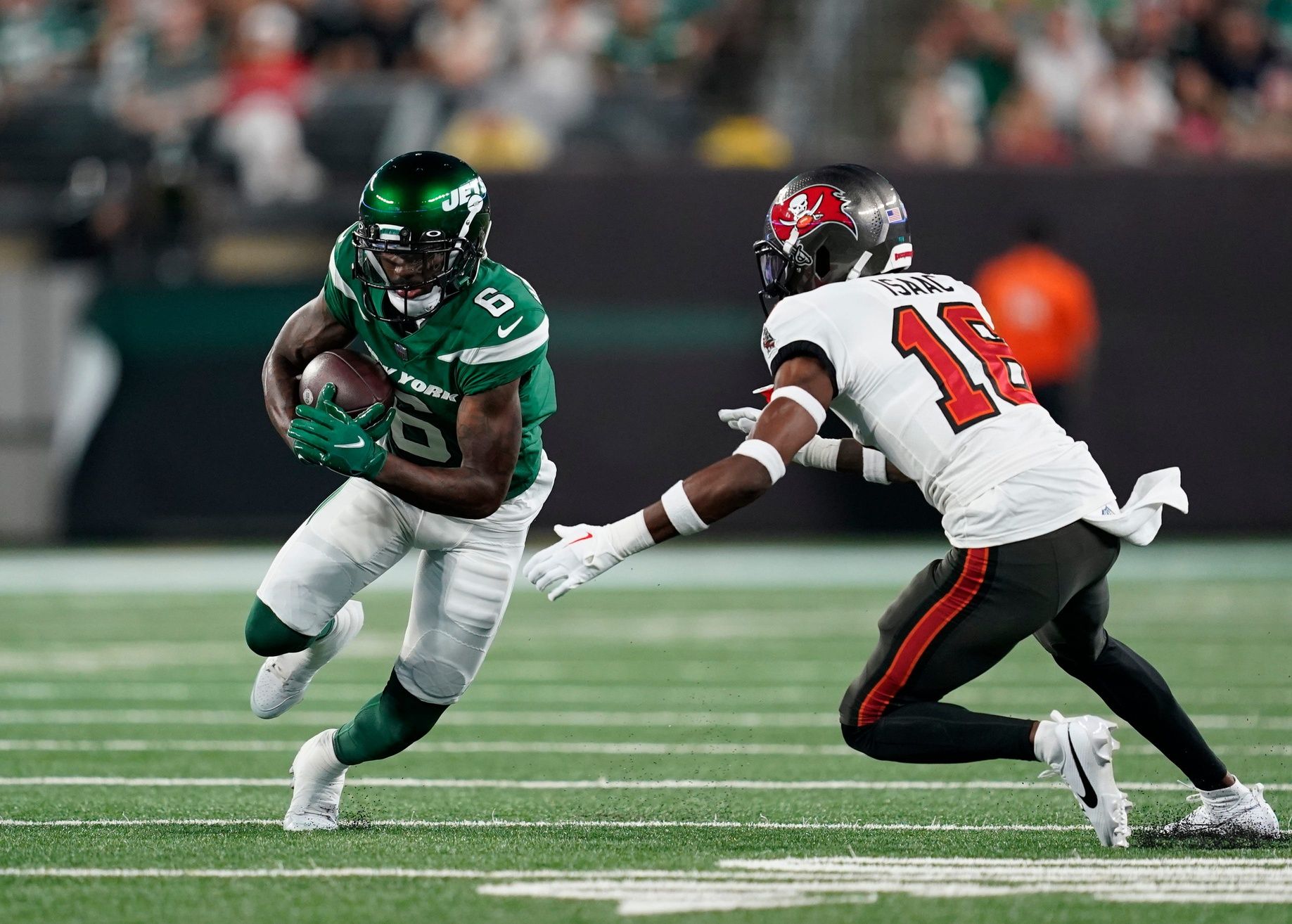 Mecole Hardman Jr. (6) runs with the ball with pressure from Tampa Bay Buccaneers cornerback Keenan Isaac (16) in the first half of a preseason NFL game at MetLife Stadium.