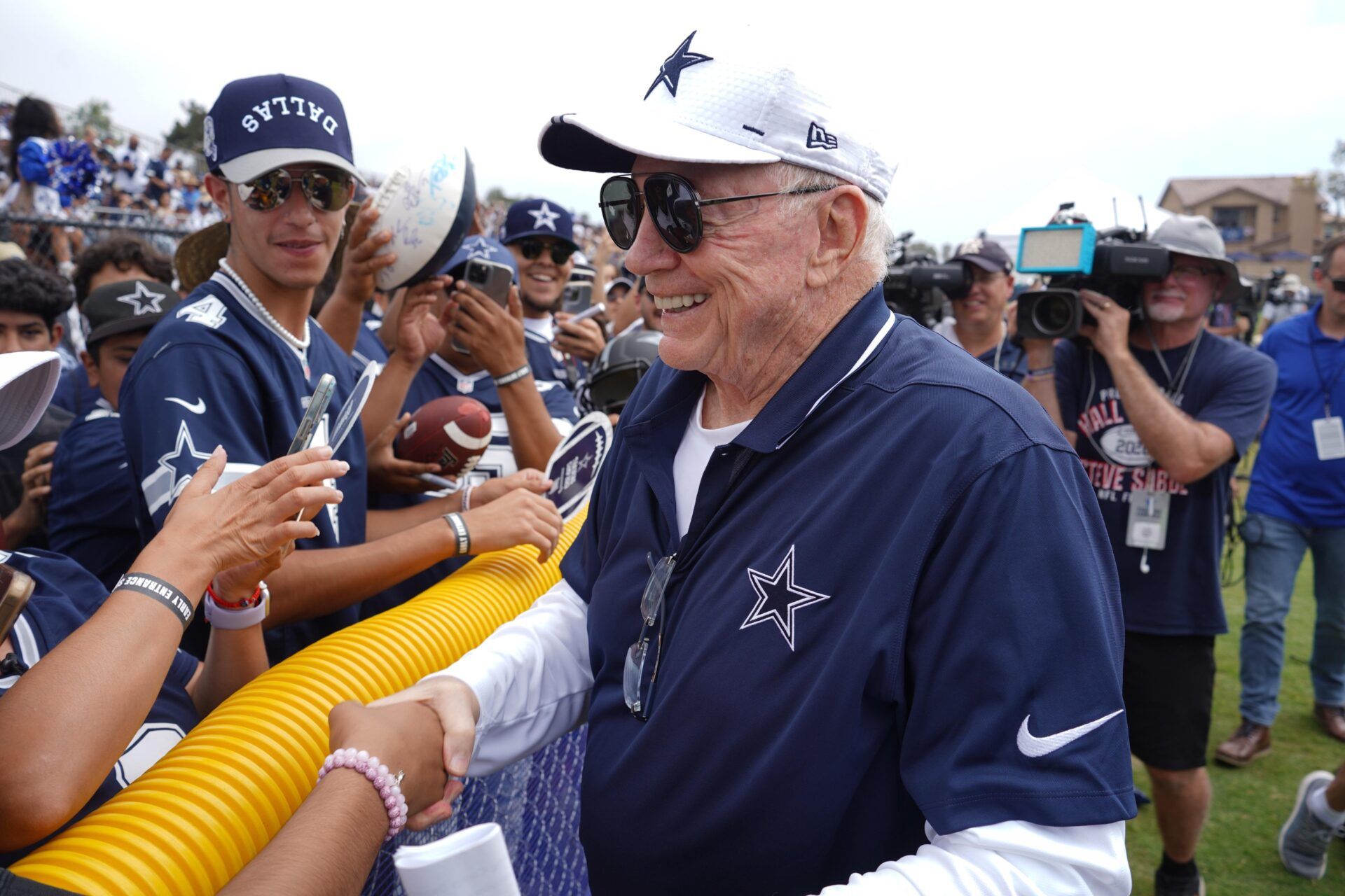 Dallas Cowboys owner Jerry Jones interacts with fans during training camp at the River Ridge Fields.