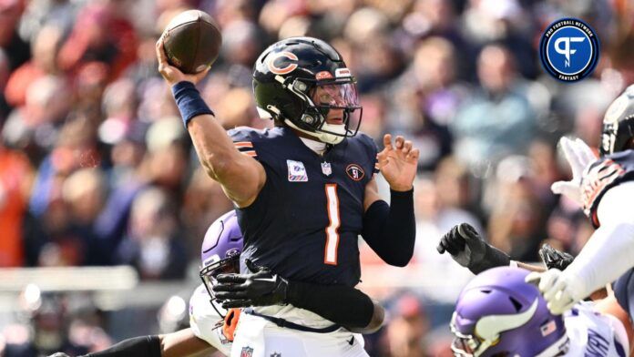 Justin Fields (1) gets off a pass while being harassed by Minnesota Vikings safety Josh Metellus (44) in the first half at Soldier Field.