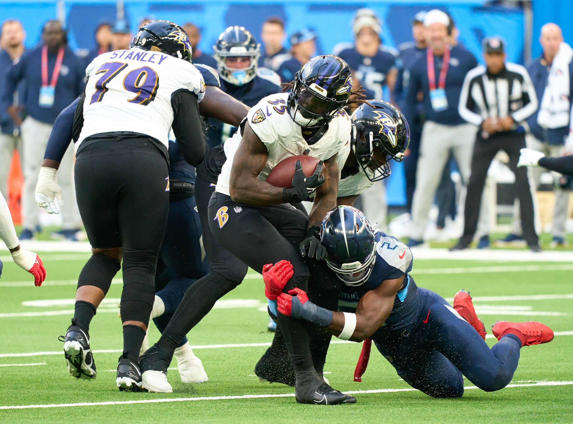 Gus Edwards (35) is tackled by Tennessee Titans linebacker Azeez Al-Shaair (2) during the second half of an NFL International Series game at Tottenham Hotspur Stadium.