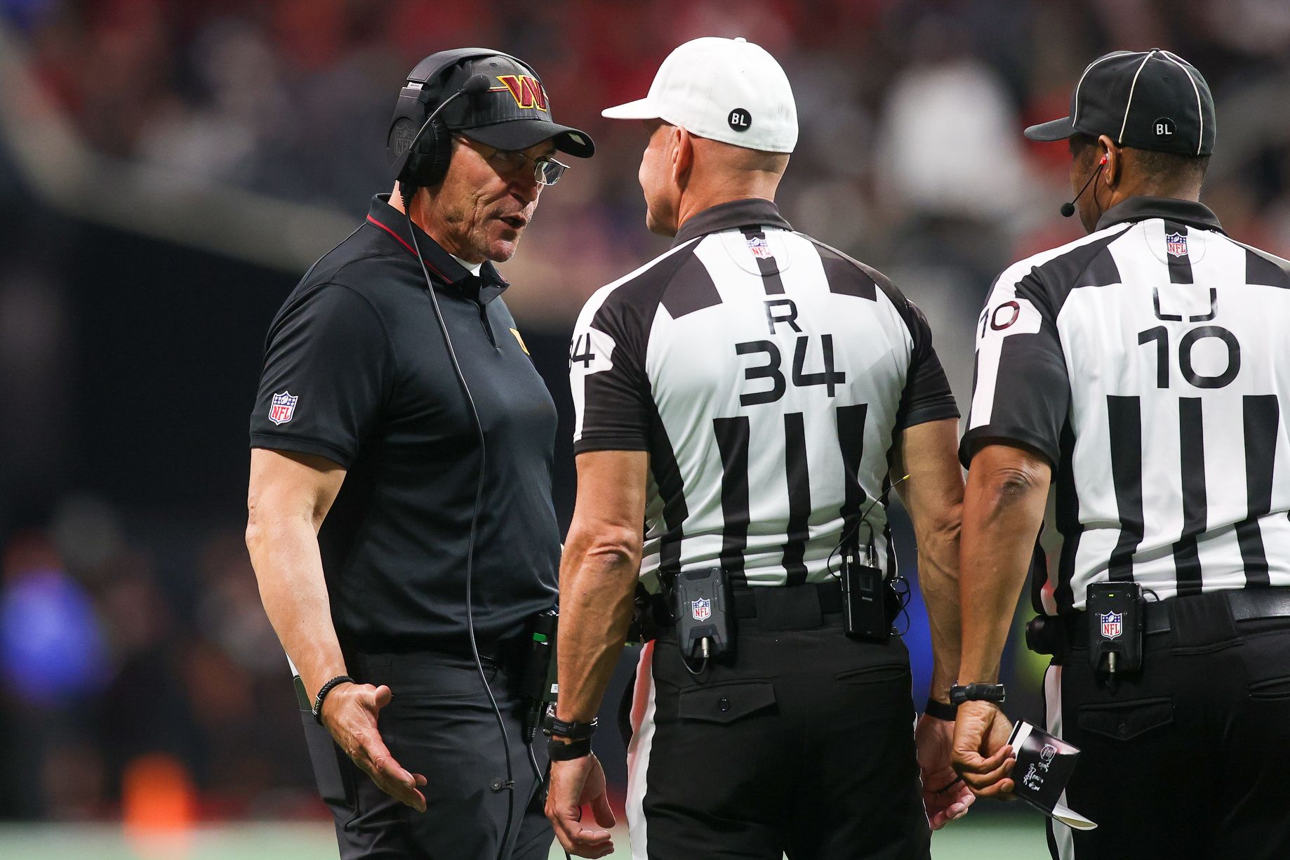 Washington Commanders head coach Ron Rivera talks to referee Clete Blakeman (34) and line judge Julian Mapp (10) against the Atlanta Falcons in the second half at Mercedes-Benz Stadium.