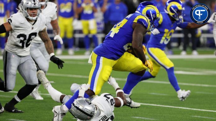 Royce Freeman (24) runs over Las Vegas Raiders cornerback Sam Webb (27) during the third quarter at SoFi Stadium.