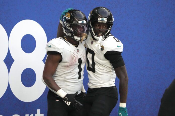 Travis Etienne Jr. (1) celebrates with wide receiver Calvin Ridley (0) after scoring on a 35-yard touchdown run against the Buffalo Bills an NFL International Series game at Tottenham Hotspur Stadium.