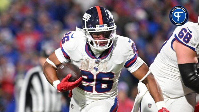 Saquon Barkley (26) carries the ball against the Buffalo Bills in the fourth quarter at Highmark Stadium.