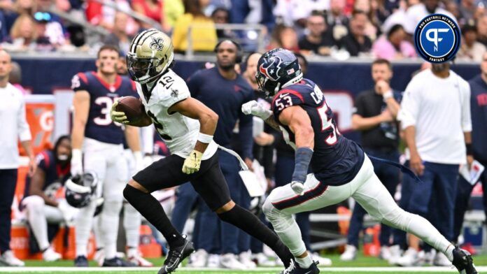 New Orleans Saints wide receiver Chris Olave (12) runs the ball as Houston Texans linebacker Blake Cashman (53) applies pressure during the third quarter at NRG Stadium.