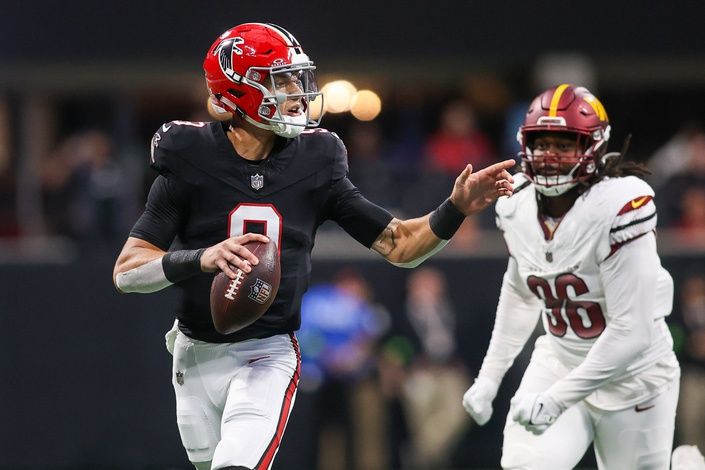 Desmond Ridder (9) scrambles past Washington Commanders defensive end James Smith-Williams (96) in the first quarter at Mercedes-Benz Stadium.