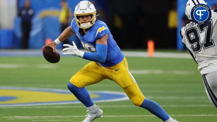 Los Angeles Chargers quarterback Justin Herbert (10) runs away from Dallas Cowboys defensive tackle Osa Odighizuwa (97) during the third quarter at SoFi Stadium.