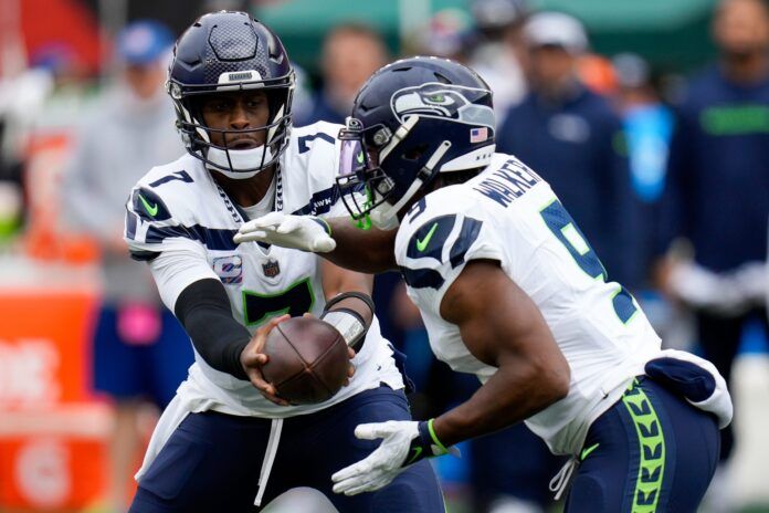 Geno Smith (7) hands off to Seattle Seahawks running back Kenneth Walker III (9) in the first quarter of the NFL Week 6 game between the Cincinnati Bengals and the Seattle Seahawks at Paycor Stadium.