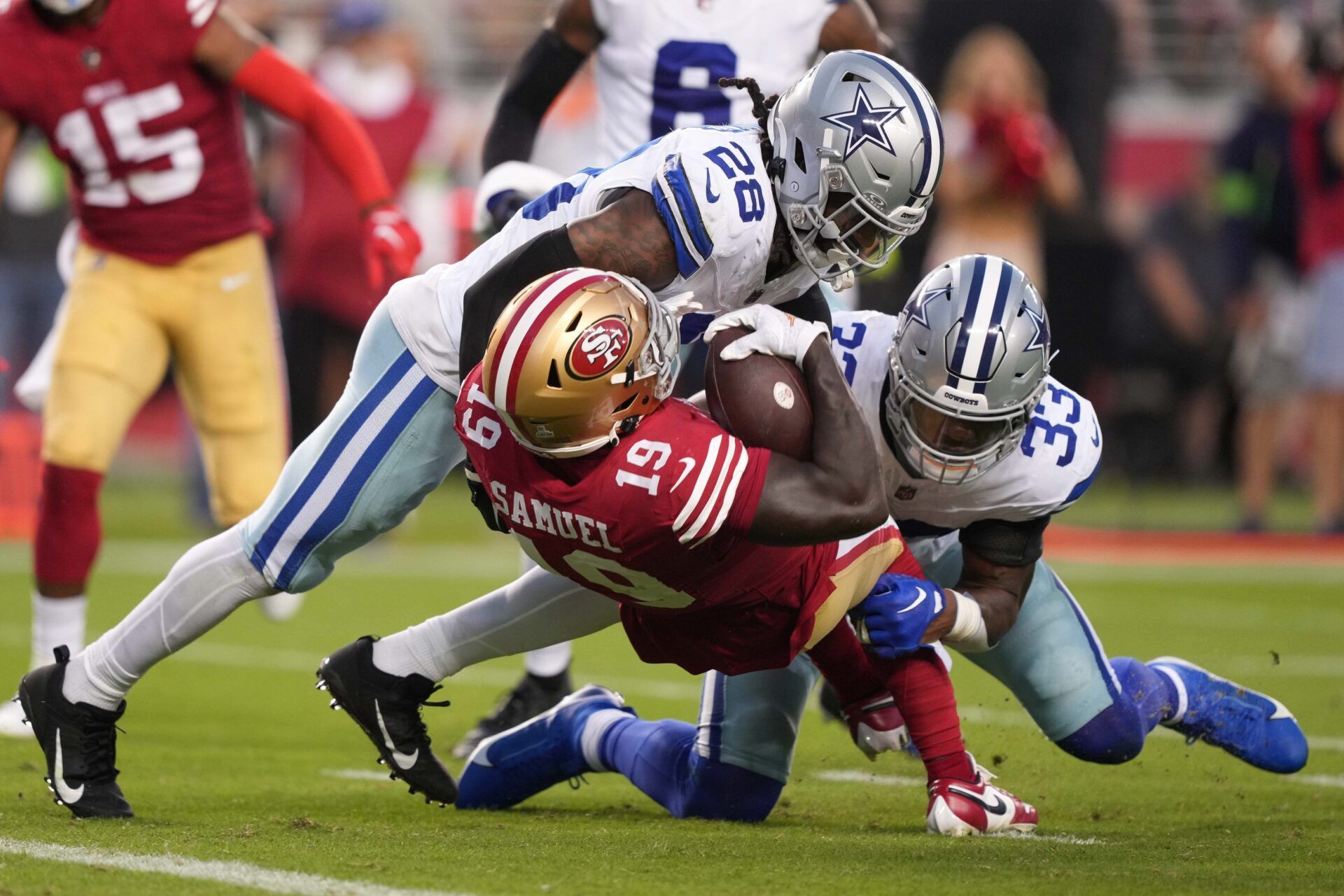 Dallas Cowboys safety Malik Hooker (28) and linebacker Damone Clark (33) tackle San Francisco 49ers wide receiver Deebo Samuel (19) during the second quarter at Levi's Stadium.