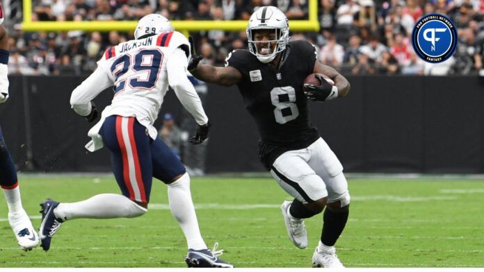 Las Vegas Raiders running back Josh Jacobs (8) runs the ball against New England Patriots cornerback J.C. Jackson (29) in the first quarter at Allegiant Stadium.