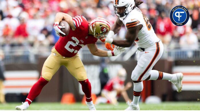 San Francisco 49ers running back Christian McCaffrey (23) runs the ball as Cleveland Browns defensive end Za'Darius Smith (99) grabs him by the face mask.