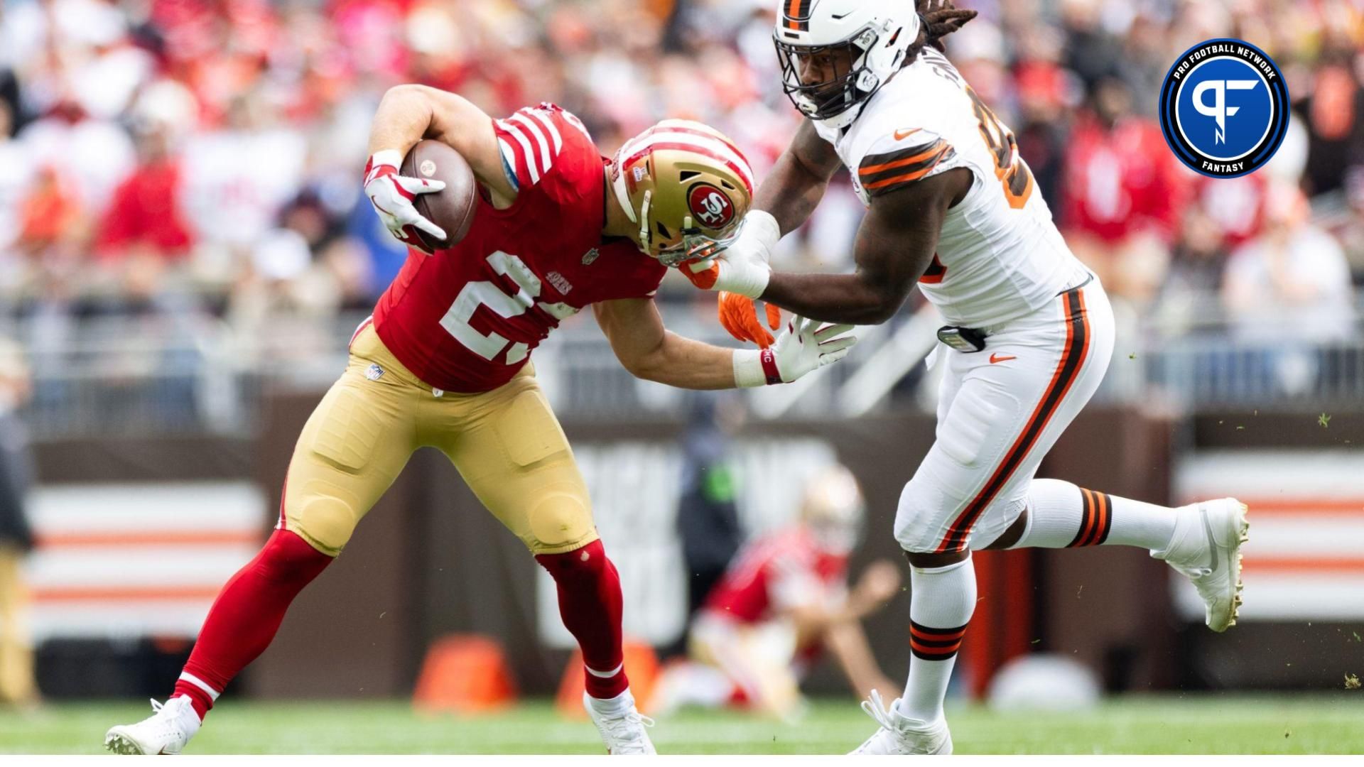 San Francisco 49ers running back Christian McCaffrey (23) runs the ball as Cleveland Browns defensive end Za'Darius Smith (99) grabs him by the face mask.