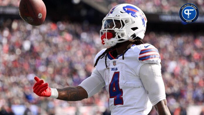 James Cook (4) tosses the ball after rushes against the New England Patriots during the first half at Gillette Stadium.