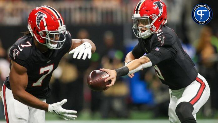 Atlanta Falcons running back Bijan Robinson (7) takes a handoff from quarterback Desmond Ridder (9) against the Washington Commanders.