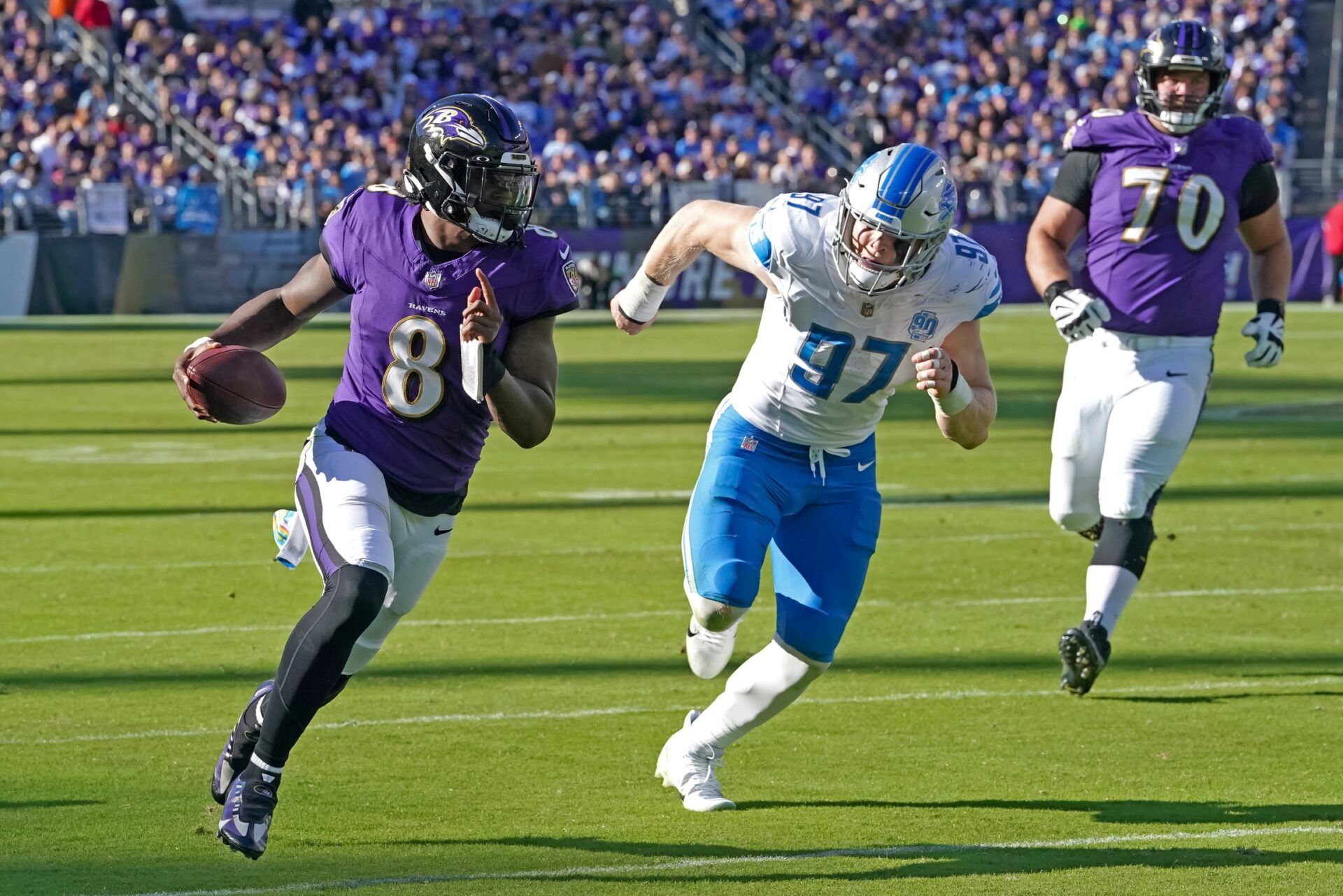 Baltimore Ravens quarterback Lamar Jackson (8) is pressured by Detroit Lions defensive lineman Aidan Hutchinson (97).