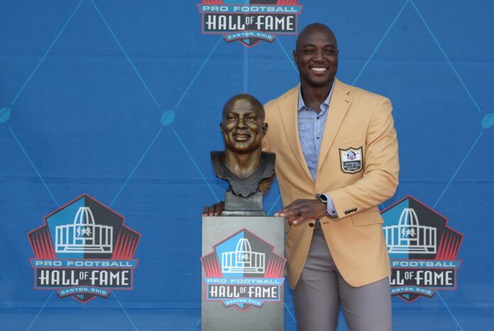 Former Dallas Cowboys linebacker DeMarcus Ware poses with his bust at the Pro Football Hall of Fame.