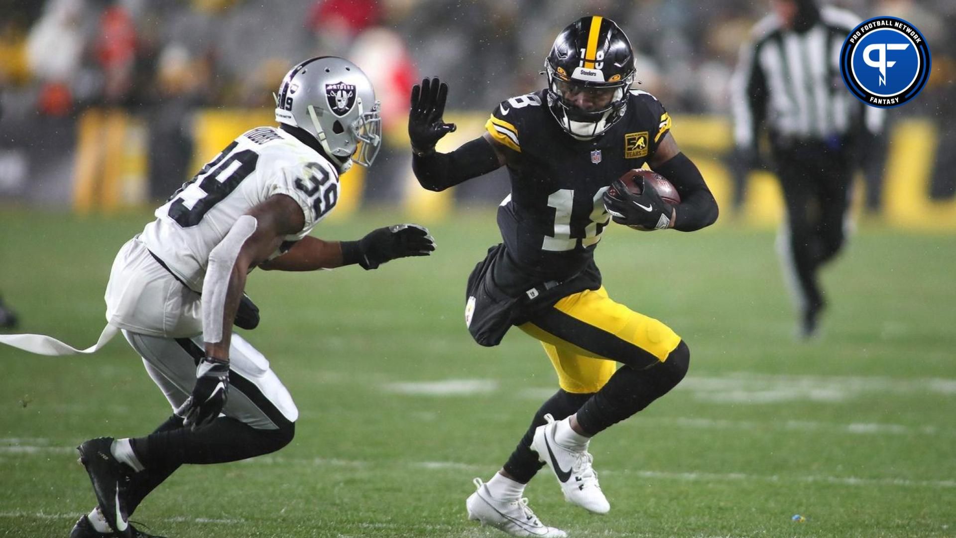 Pittsburgh Steelers Diontae Johnson (18) stiff arms Las Vegas Raiders Nate Hobbs (39).