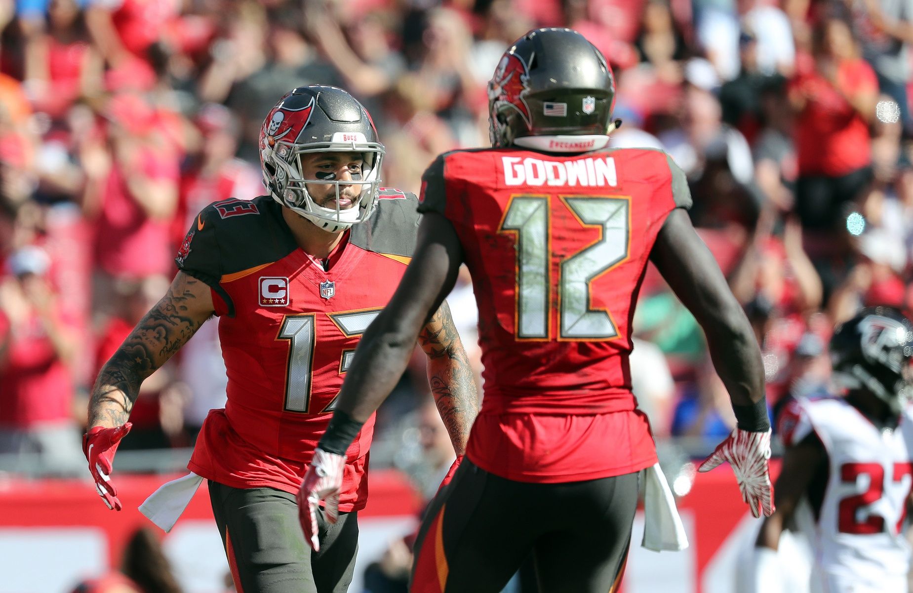 Tampa Bay Buccaneers WRs Mike Evans (13) and Chris Godwin (12) celebrate after a touchdown.