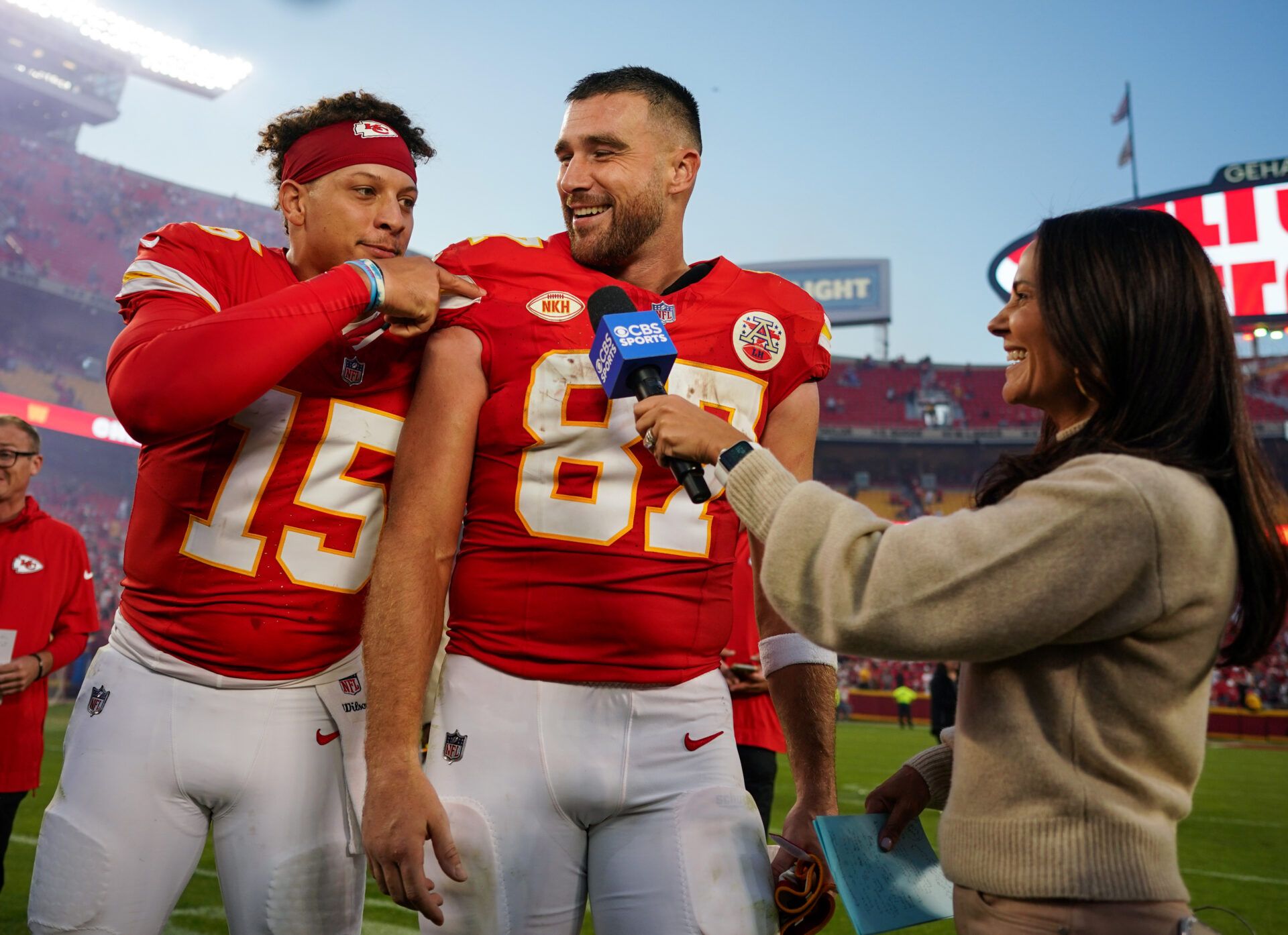 Kansas City Chiefs quarterback Patrick Mahomes (15) and tight end Travis Kelce (87) talk with reporter Tracy Wolfson after defeating the Los Angeles Chargers at GEHA Field at Arrowhead Stadium.
