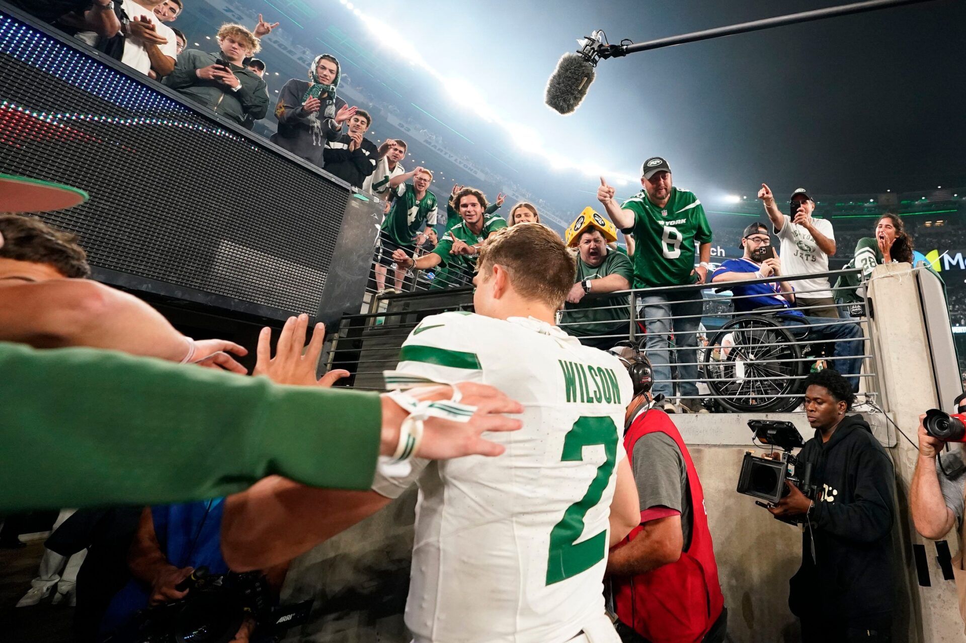 Fans high-five New York Jets quarterback Zach Wilson (2) as he runs into the locker room after the game. The Jets defeat the Bills in overtime, 22-16, in the home opener at MetLife Stadium.