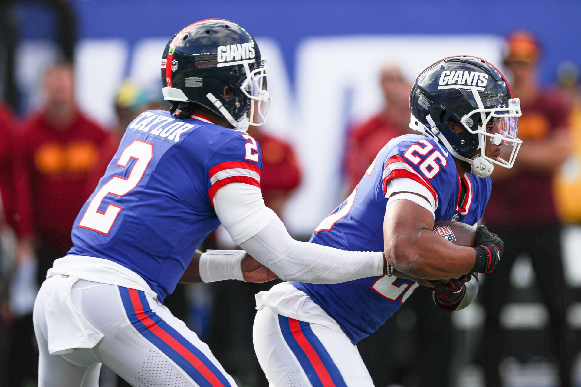 Saquon Barkley (26) takes a hand off from quarterback Tyrod Taylor (2) during the second half against the Washington Commanders at MetLife Stadium.