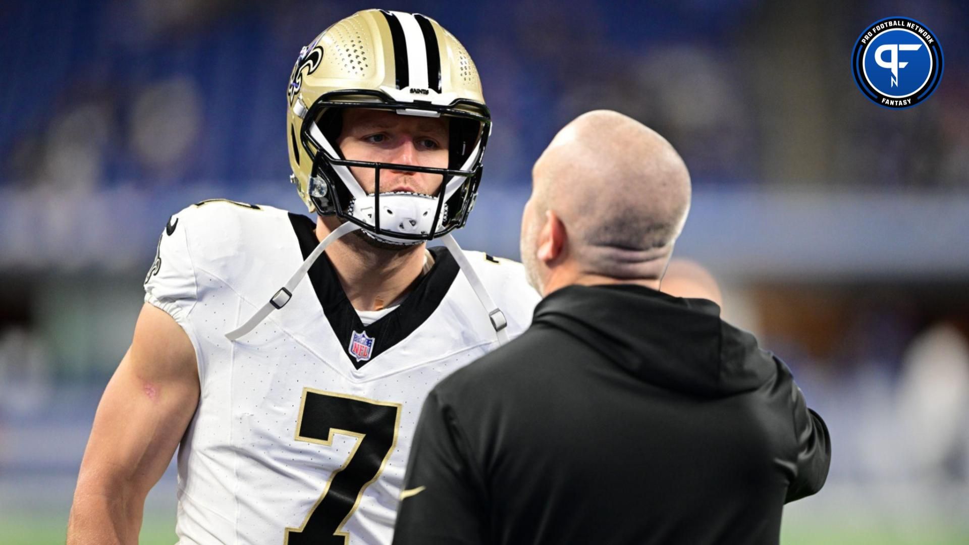 Taysom Hill (7) talks to a coach during warm ups before the game against the Indianapolis Colts at Lucas Oil Stadium.