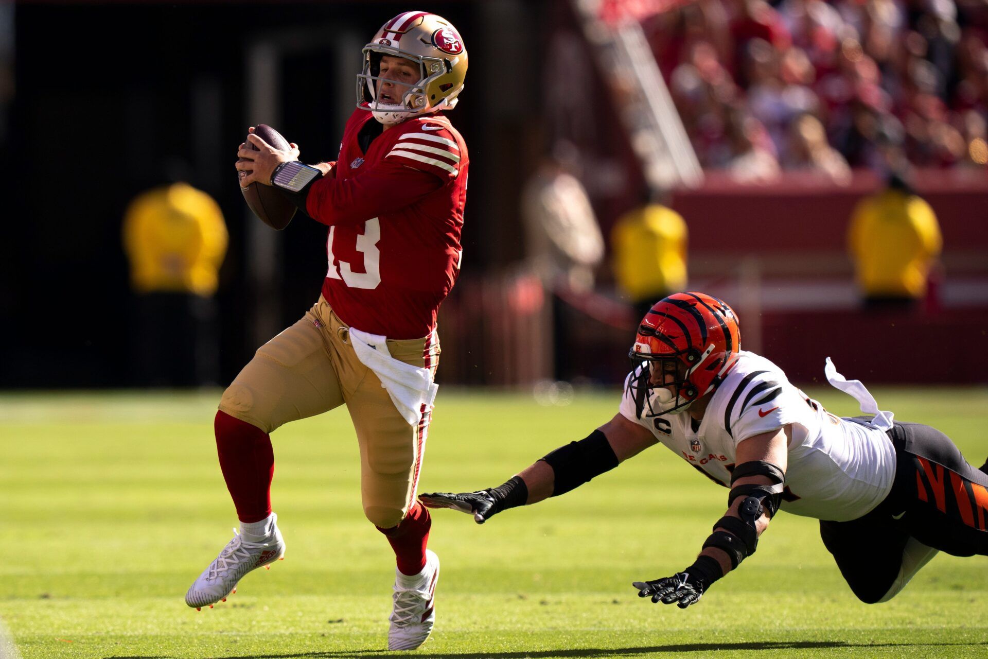 Brock Purdy (13) runs from Cincinnati Bengals defensive end Sam Hubbard (94) in the second quarter of the NFL game between the Cincinnati Bengals and the San Francisco 49ers at Levi Stadium.