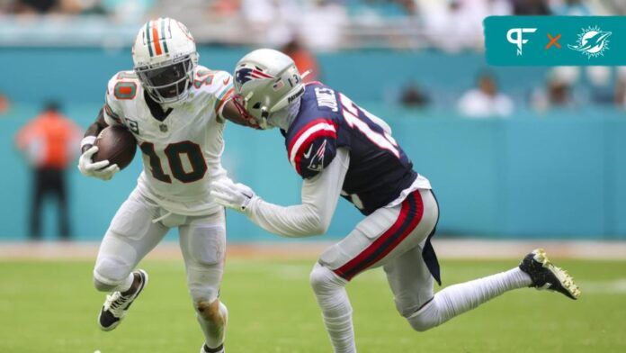 Miami Dolphins WR Tyreek Hill (10) attempts to fight off New England Patriots CB Jack Jones (13).