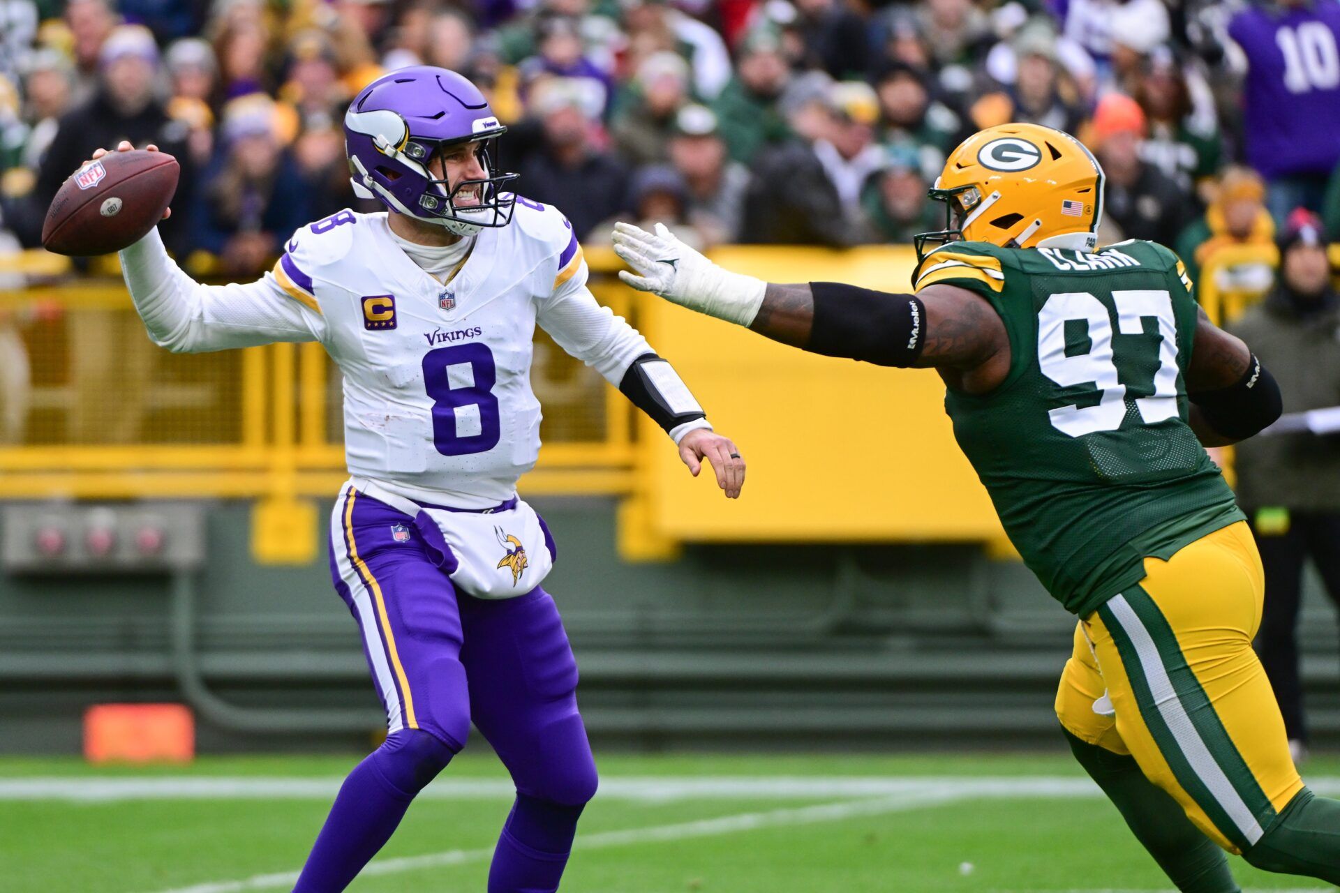 Kirk Cousins (8) gets pressure from Green Bay Packers linebacker Kenny Clark (97) in the first quarter at Lambeau Field.