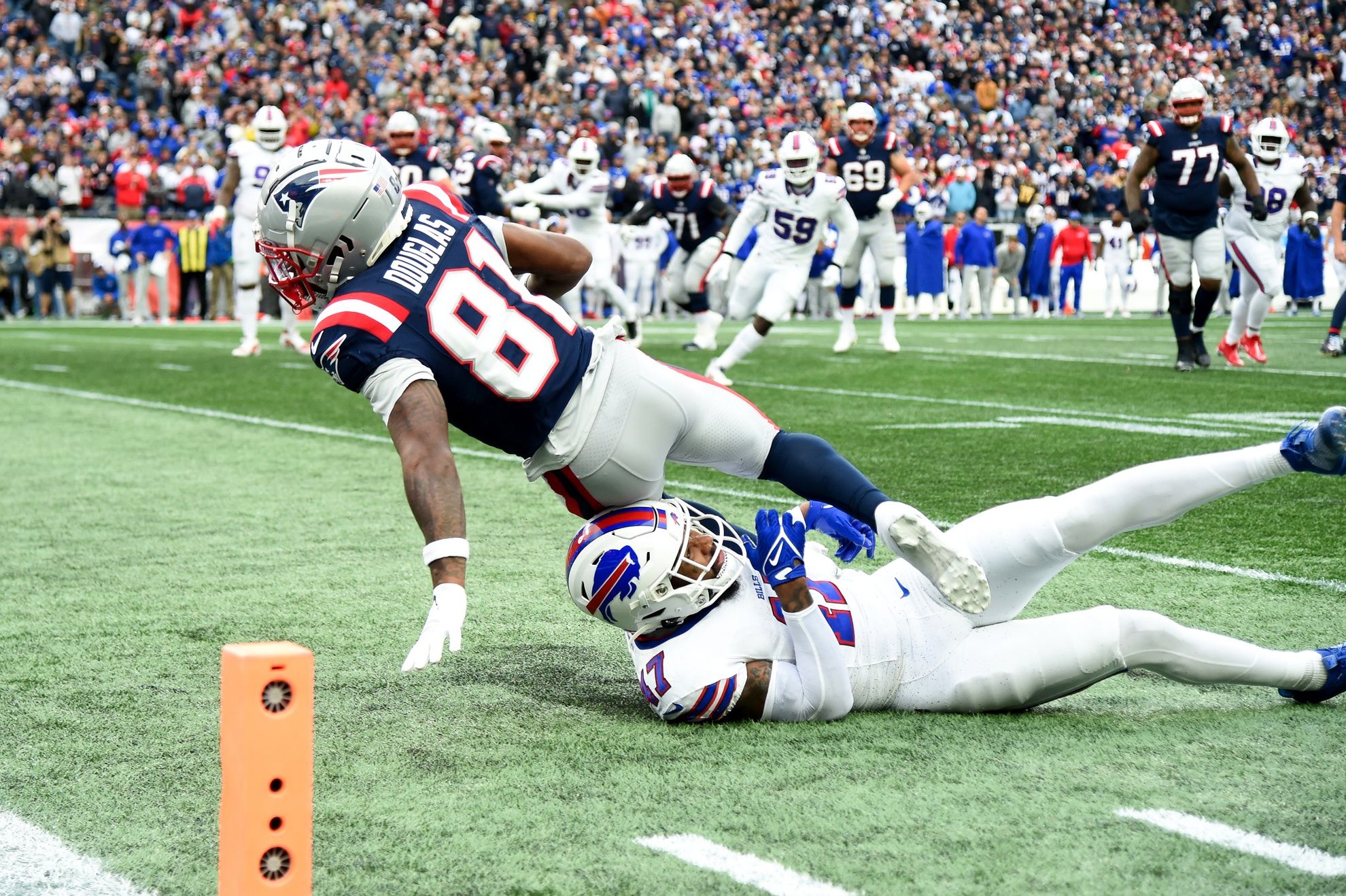 Buffalo Bills cornerback Christian Benford (47) tackles New England Patriots wide receiver Demario Douglas (81) during the second half at Gillette Stadium.