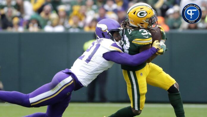 Minnesota Vikings cornerback Akayleb Evans (21) tackles Green Bay Packers running back Aaron Jones (33).