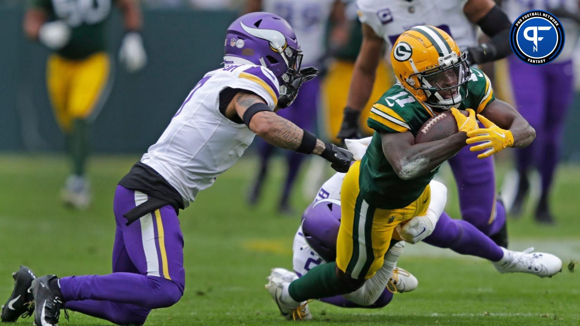 Green Bay Packers wide receiver Jayden Reed (11) lunges for a first down against Minnesota Vikings cornerback Byron Murphy Jr. (7) and safety Camryn Bynum (24).