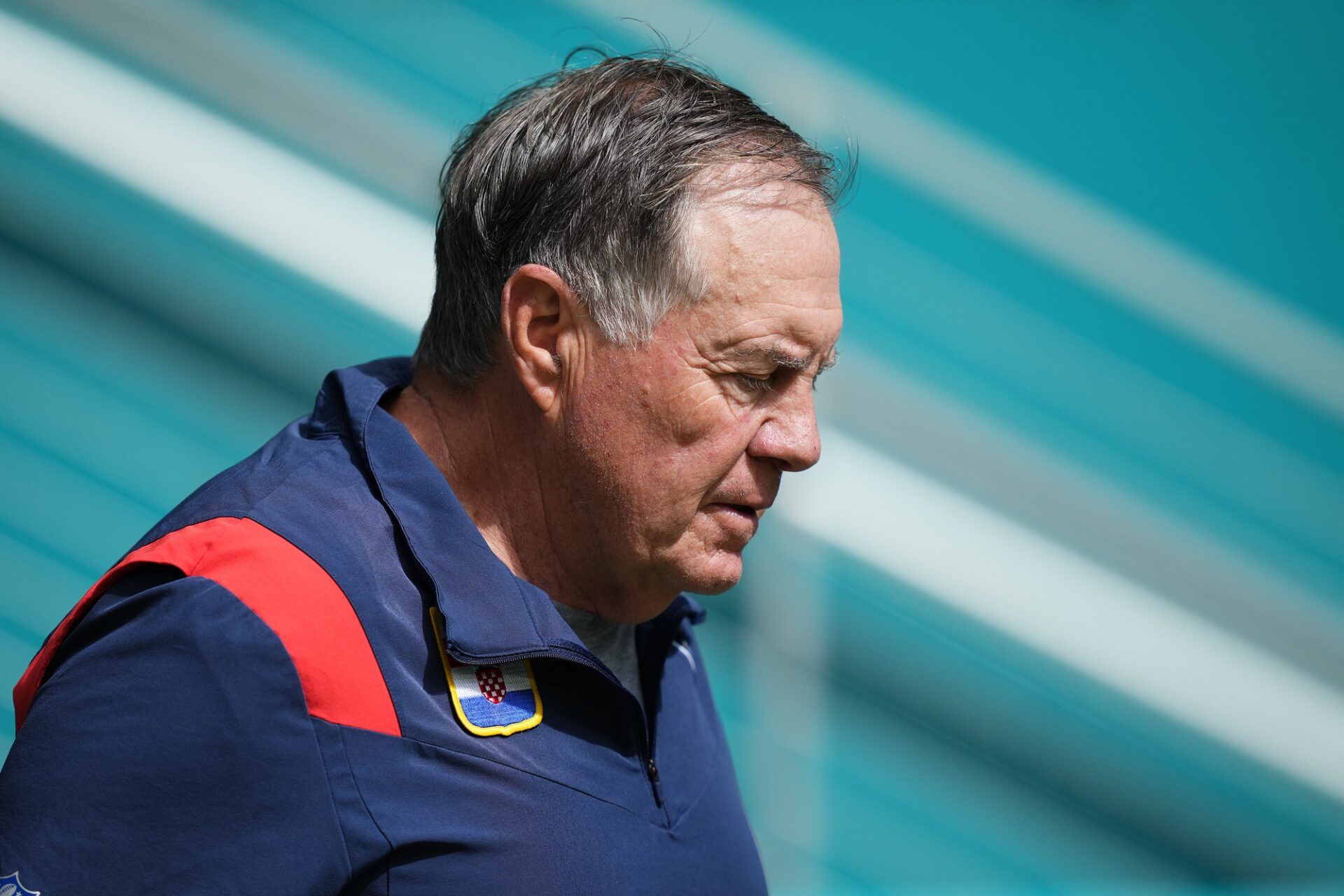 New England Patriots head coach Bill Belichick walks onto the field against the Miami Dolphins.