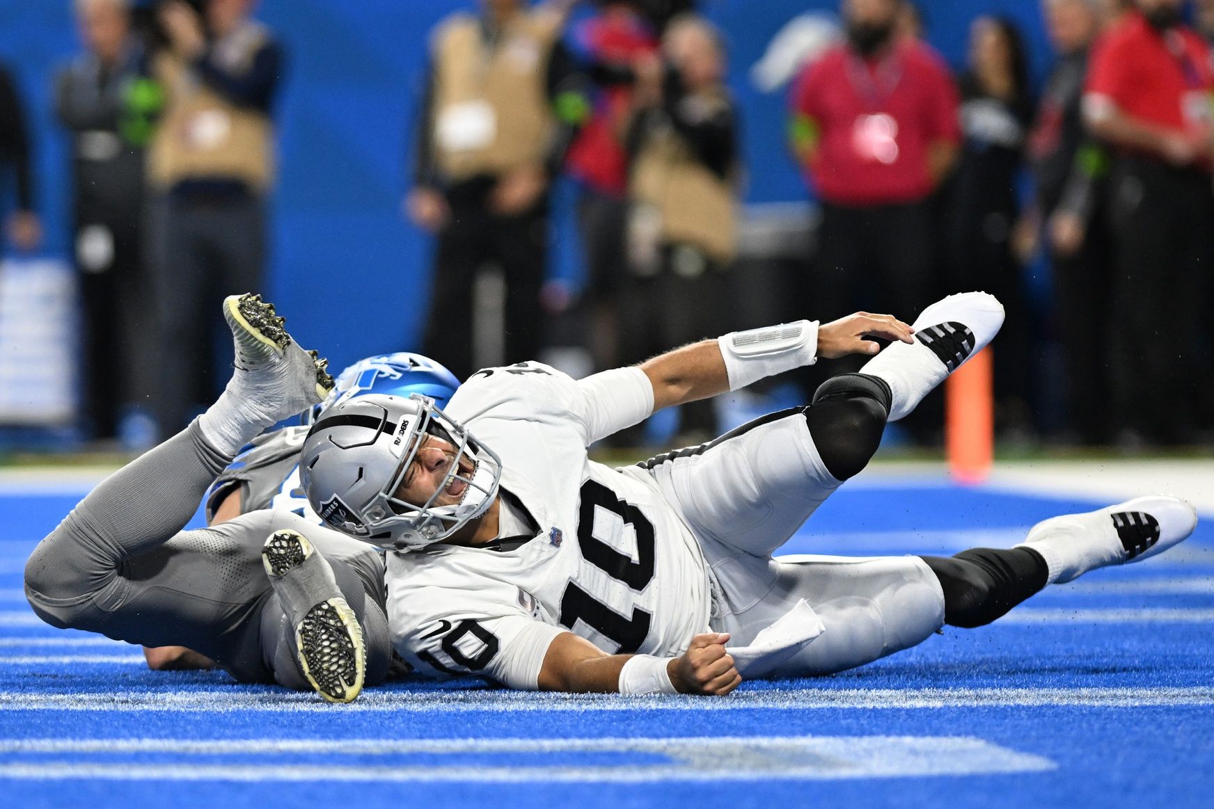 Jimmy Garoppolo (10) grimaces in pain as he grabs his ankle after being hit in the end zone by Detroit Lions linebacker Jack Campbell (46) in the fourth quarter at Ford Field.