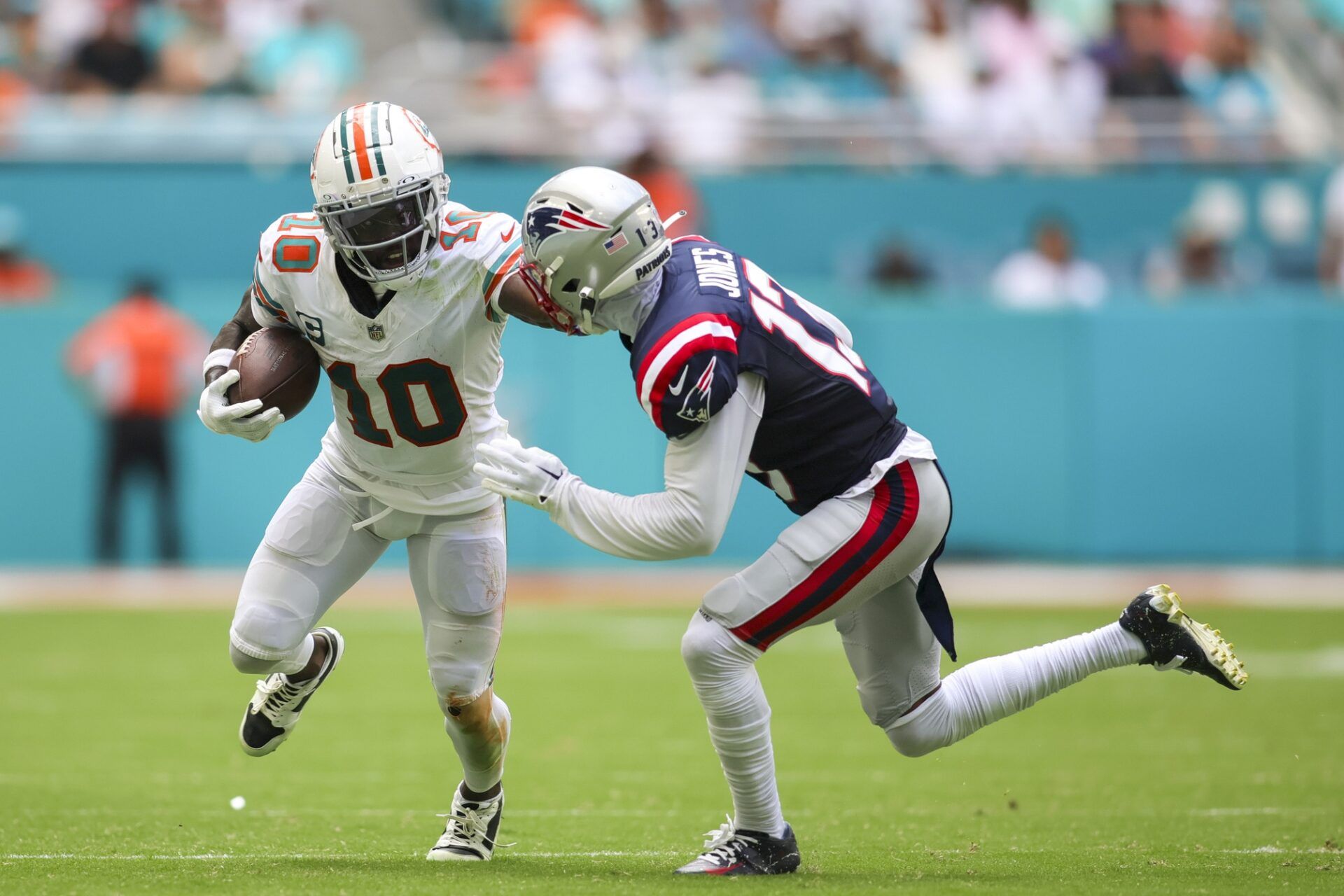 Miami Dolphins wide receiver Tyreek Hill (10) runs with the football against New England Patriots cornerback Jack Jones (13) during the second quarter at Hard Rock Stadium.