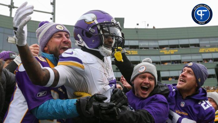 Minnesota Vikings wide receiver Jordan Addison (3) does a Lambeau Leap with Vikings fans.