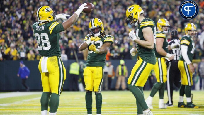 AJ Dillon (28) celebrates with running back Aaron Jones (33) and tight end Tyler Davis (84) after scoring a touchdown during the fourth quarter at Lambeau Field.