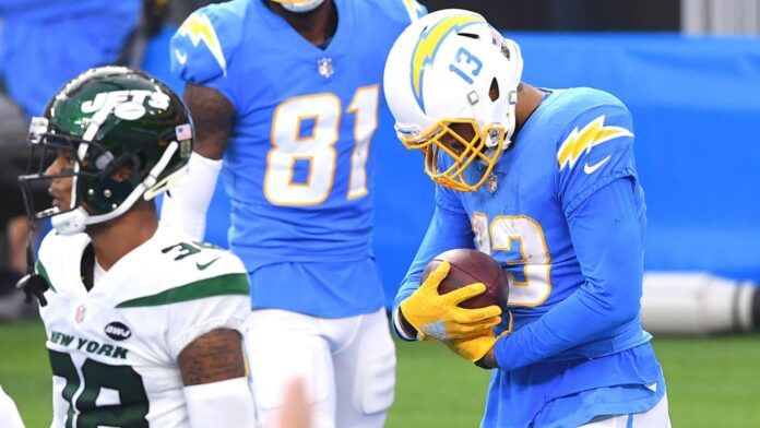 Los Angeles Chargers wide receiver Keenan Allen (13) cradles the ball after catching a touchdown pass against the New York Jets in the second half at SoFi Stadium.